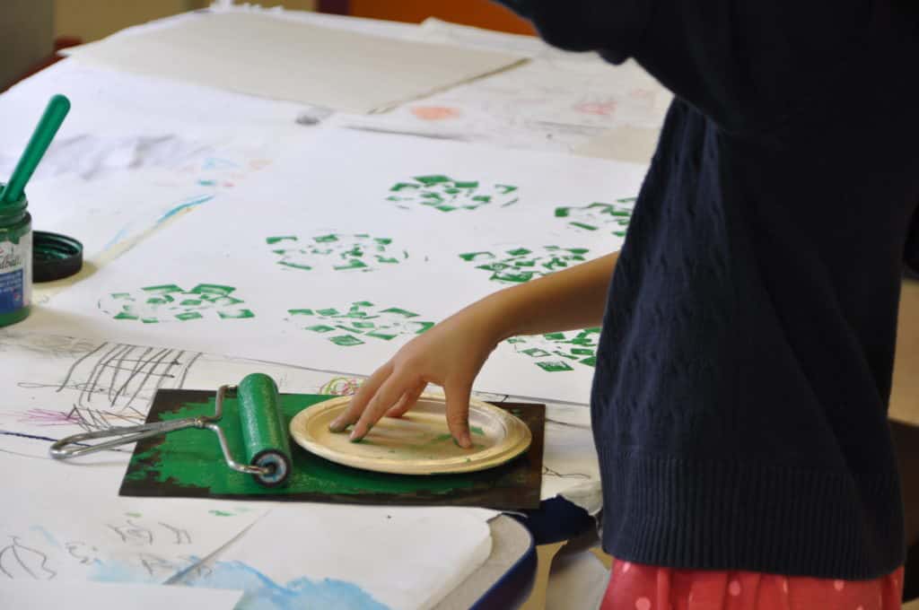 child with paint roller and plate